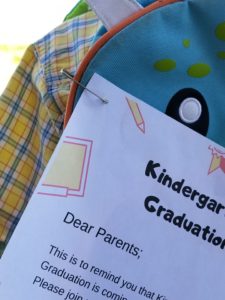 a school note safety pinned to a childs backpack